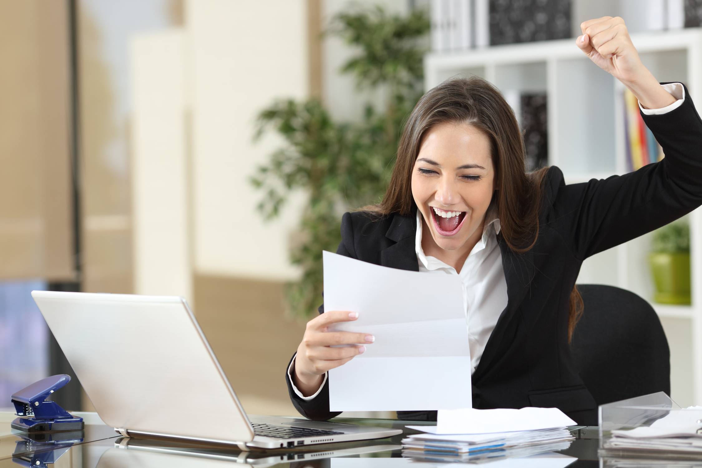 Excited businesswoman reading good news in letter